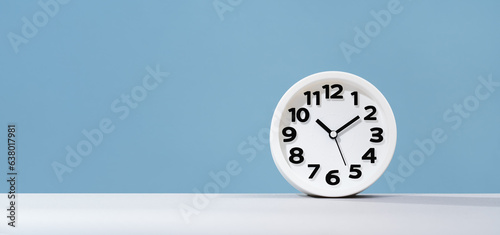 Plain wall clock on pastel blue background desk. Ten o'clock. copy space, time management or business concept. Opening or closing hours. Schedule or working hours. daylight saving time