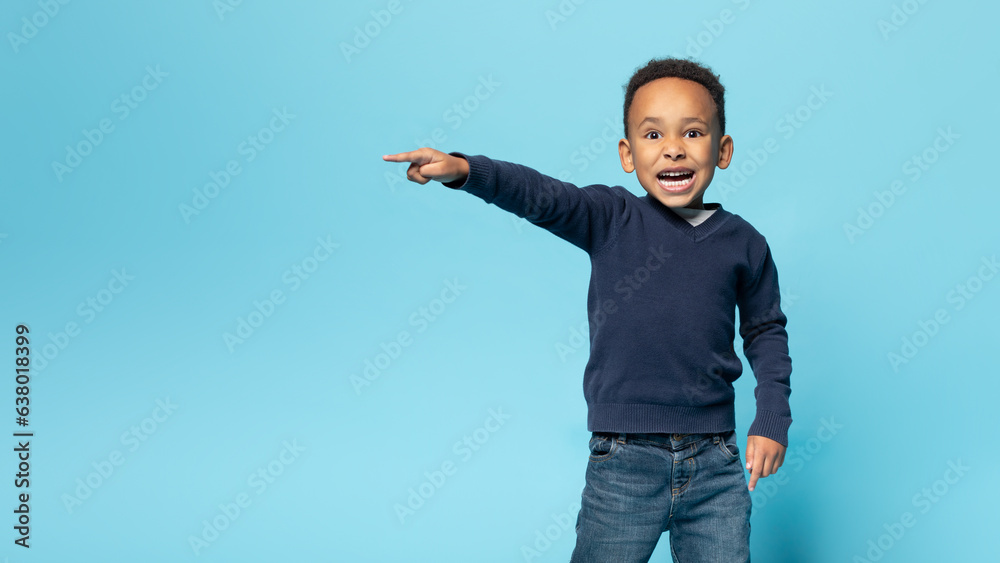 Funny african american boy pointing aside at copy space, emotional male child demonstrating free place for ad Funny african american boy pointing aside at copy space, emotional male child demonstrating free place for ad