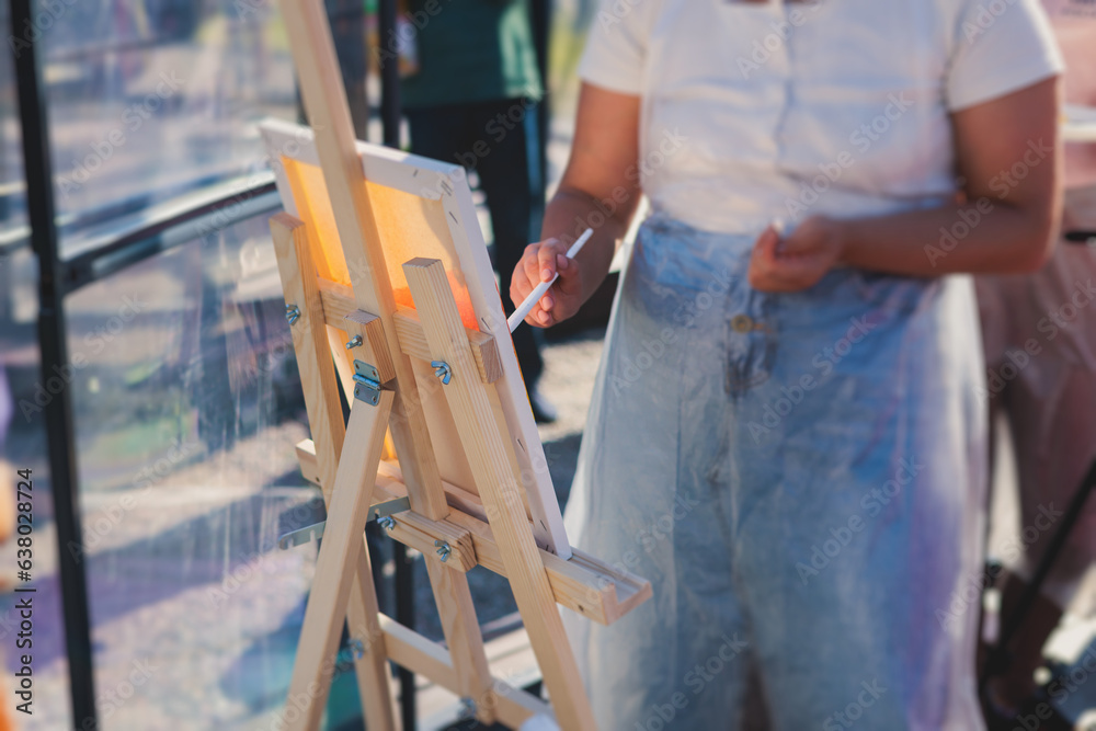 Process of drawing, group class of talented students with painting easels and canvases during lesson of watercolour painting outdoors, drawing class for adult artists in art school Process of drawing, group class of talented students with painting easels and canvases during lesson of watercolour painting outdoors, drawing class for adult artists in art school