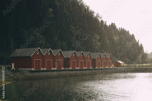 red wooden houses on the shore of a fjord in Norway in rainy weather