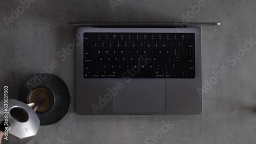 Businessman typing on a computer keyboard and pouring coffee