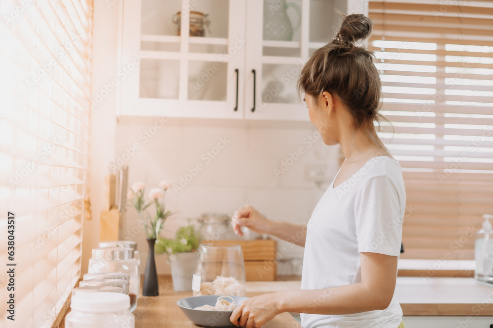 Asian woman preparing breakfast in the kitchen in the morning.