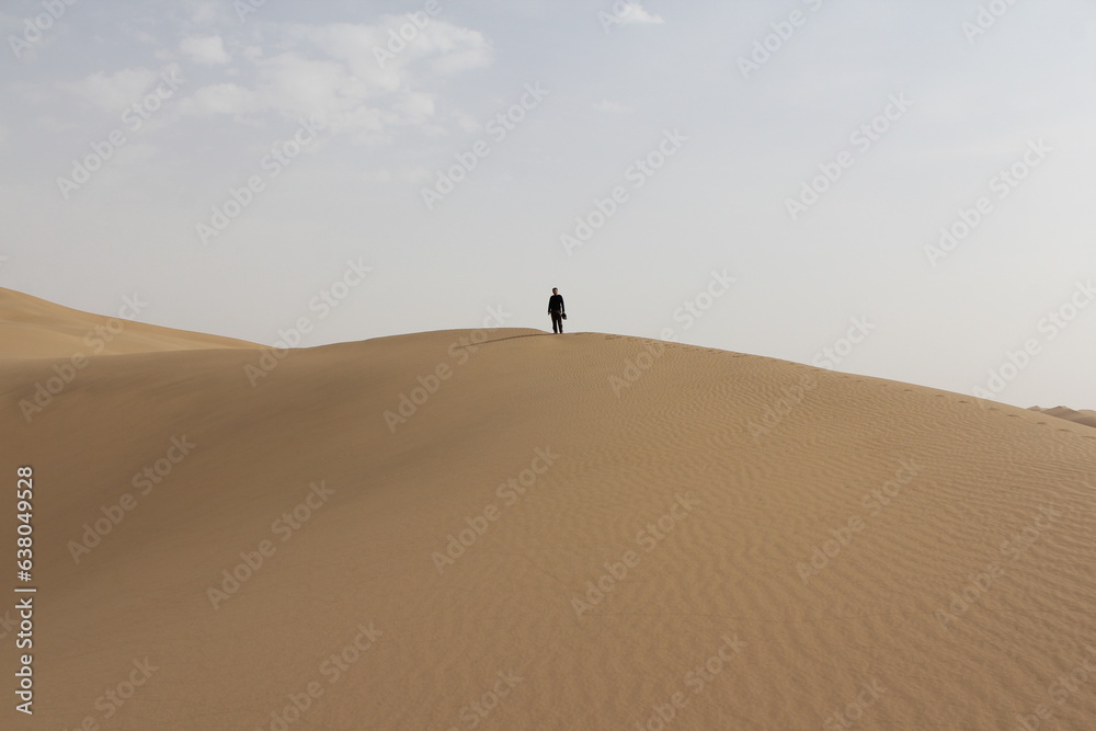 person walking on the sand dunes