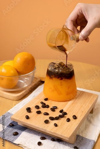 photoshoot of hand pours coffee in Orange Espresso in close up 
