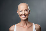 Portrait of a beautiful smiling middle aged woman with no hair, cancer survivor, over dark gray background.