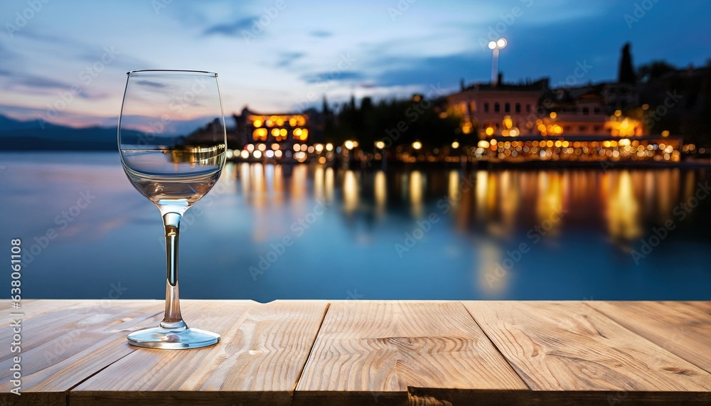  wooden table top with glass of wine with blurred lakeside cafe on a gorgeous Italian lake at night celebration,  christmas party, christmas night 2023