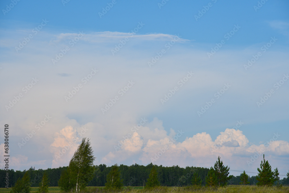 Beautiful thunderstorm landscape in the countryside. Thunderclouds and a horizon with a forest.
