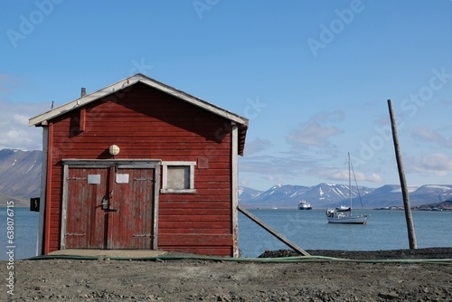 Traditional wooden building standing on coast of fjord in Longyearbyen. Former mining town Longyearbyen, capital of Svalbard, Spitsbergen, Norway. 