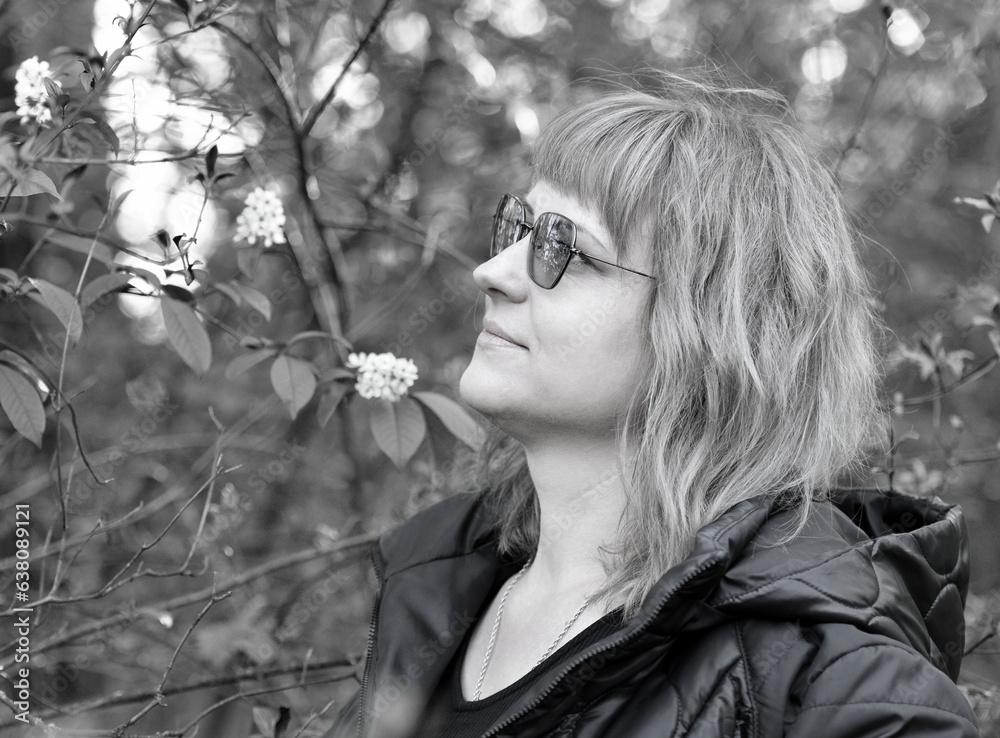 girl in the woods. young woman in a green forest enjoys the silence and beauty of nature. tourist girl, woman alone in the park. relaxing in the nature. close-up portrait of a woman with glasses