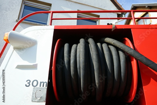 Feuerwehrauto und Tanklöschfahrzeug der Fünfzigerjahre in Rot und Weiß mit Schlauchtrommel bei Sonnenschein beim Oldtimertreffen Golden Oldies in Wettenberg Krofdorf-Gleiberg bei Gießen in Hessen photo