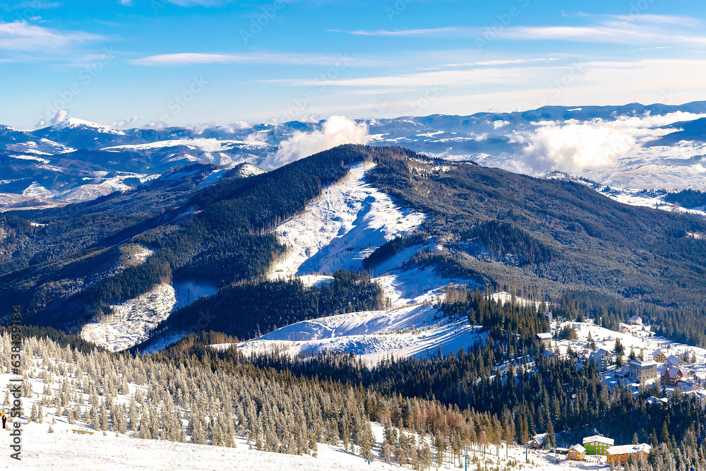 Winter beautiful scenic bright nature mountains panorama on ski resort.Pine fir spruce trees covered with snow ice in forest in sunny cold frosty day.Ukrainian Carpathians landscape