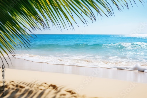 sand beach with blue water wave and palm leaves in sunshine