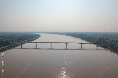 Aerial view of Thai Laos bridge with Mekong River with green mountain hill. Nature landscape background in Ubon Ratchathani, Thailand.