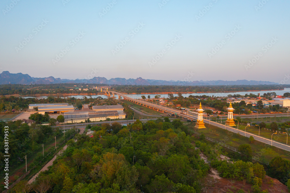 Aerial view of Thai Laos bridge with Mekong River with green mountain hill. Nature landscape background in Ubon Ratchathani, Thailand.