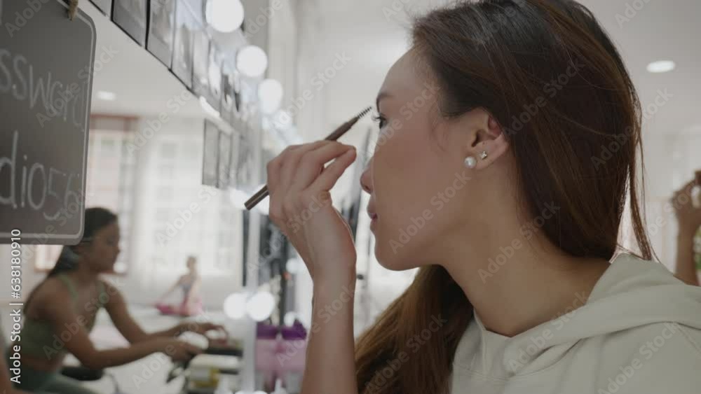 Cheerful diverse women applying makeup against mirror