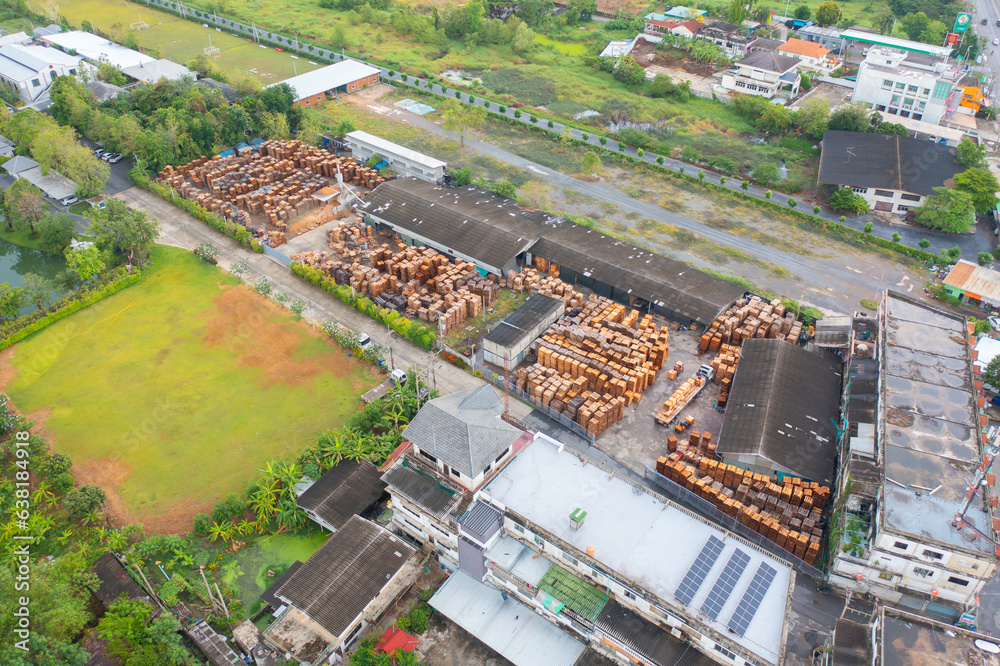 Aerial top view of wood industry factory in urban city town. Business distribution logistic transport in Thailand.