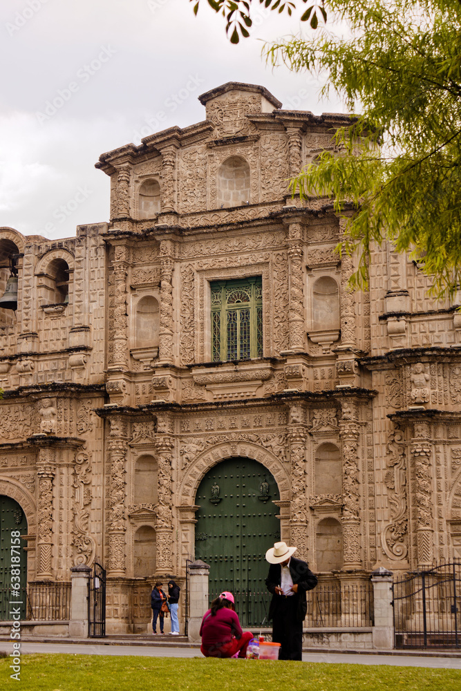 man with traditional hat stand up in front of the cathedral of Cajamarca.