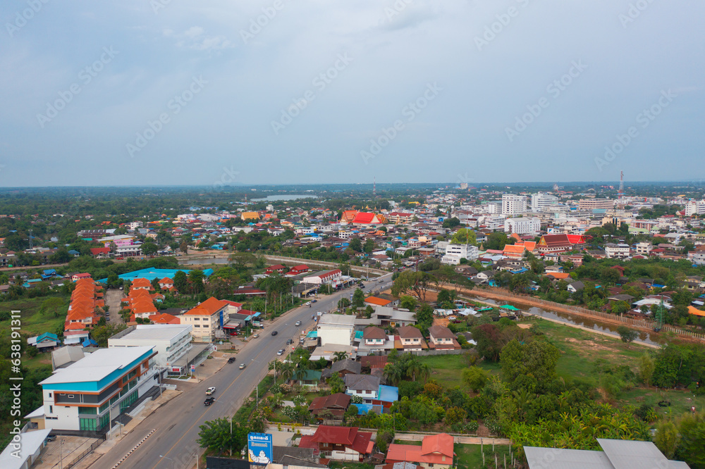 Naklejka premium Aerial view of residential neighborhood roofs. Urban housing development from above. Top view. Real estate in Kalasin, Isan province city, Thailand. Property real estate.