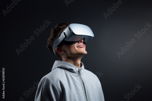 Man wearing virtual reality VR glasses, VR headset and trying to touch something with his hand while standing on dark background.