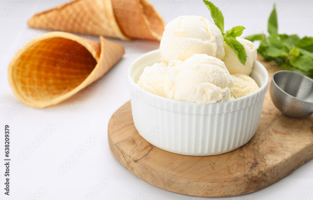 Bowl of ice cream and mint leaves on white table