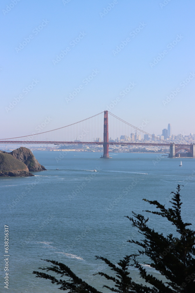 Naklejka premium A breathtaking photo of the Golden Gate Bridge shrouded in iconic San Francisco fog, its majestic red-orange towers piercing through the mist, a symbol of engineering brilliance and coastal beauty