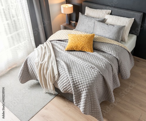Fototapeta Naklejka Na Ścianę i Meble -  Classic bedroom style with a set of pillows on the bed featuring a grey blanket and a cotton throw, fabric headboard. Interior design concept, top view
