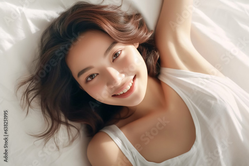 Pretty Asian young lady lies on indoor bed. She keeps eyes open and looks satisfied with positive thinking and smiling to camera. Generative AI.