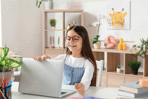 Little girl with laptop doi...