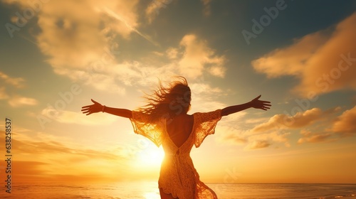 An enthusiastic adolescent girl is shown in this sunset portrait grinning and lifting her arms.
