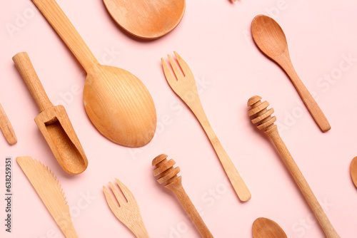Wooden kitchen utensils on pink background