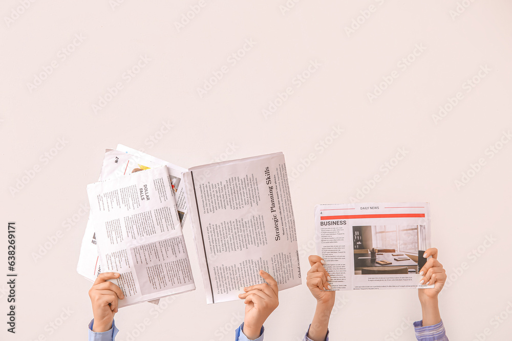 Naklejka premium Female hands with different newspapers on light background