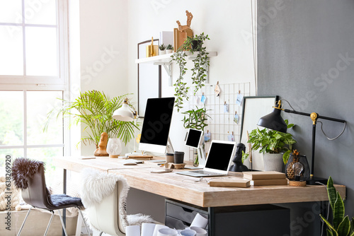 Interior of modern office with workplaces and houseplants © Pixel-Shot