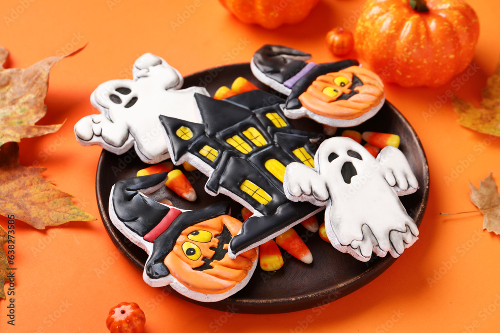 Plate with different tasty cookies for Halloween celebration on orange background, closeup