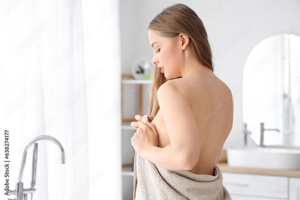 Young woman wiping with towel after shower in bathroom Young woman wiping with towel after shower in bathroom