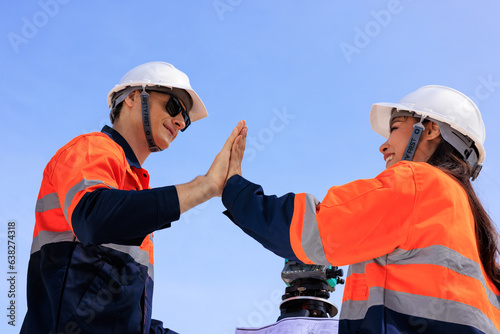engineer and surveyor engineers high five after work at road construction site, angle shot photo