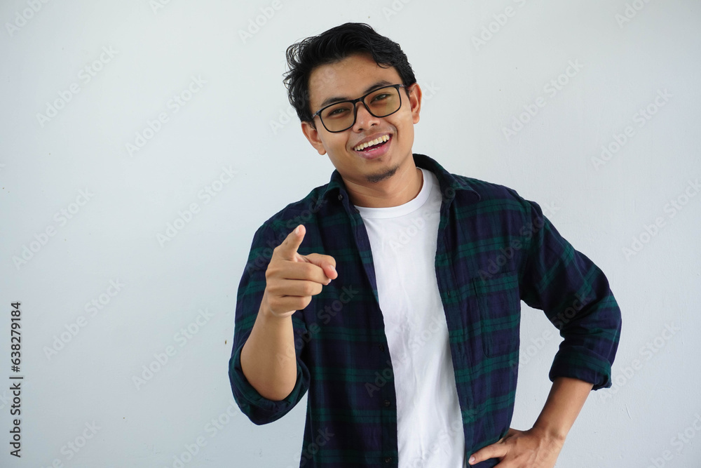 young asian man showing excited expression while pointing finger ...