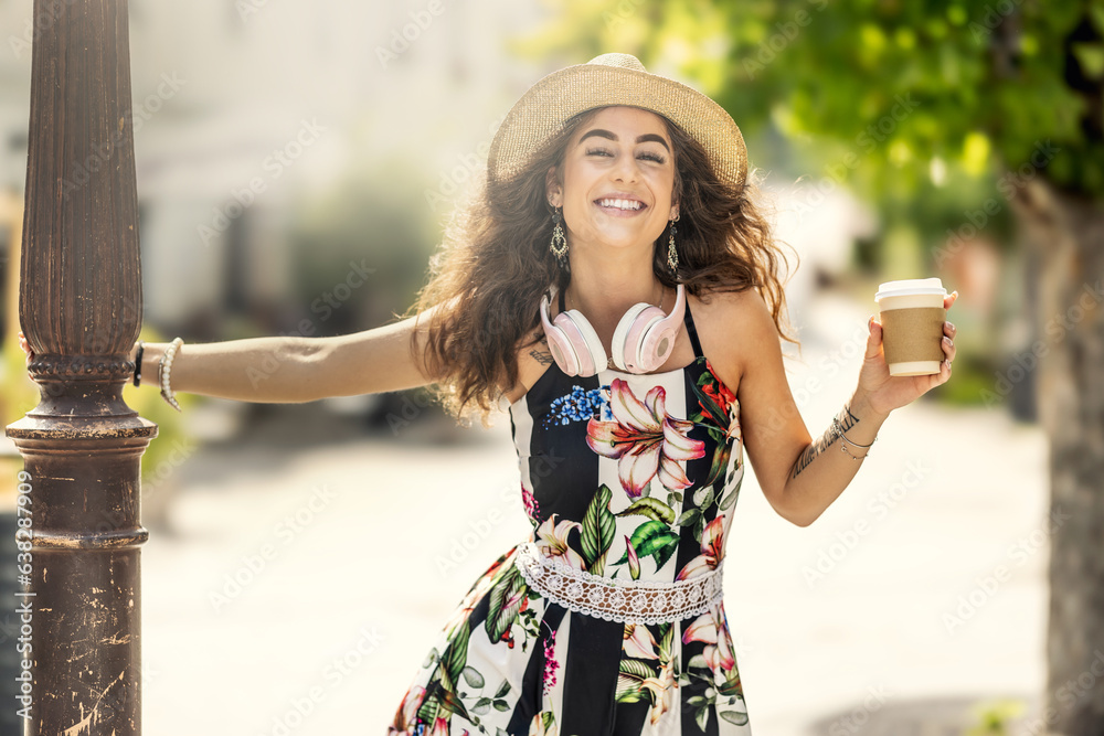 Young beautiful woman with coffee and headphones enjoying a hot summer day