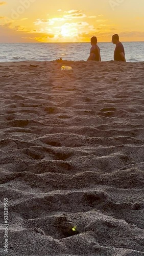 people passing at sunset, in the background sea and beach sand, sun and sunset mexico puerto vallarta
