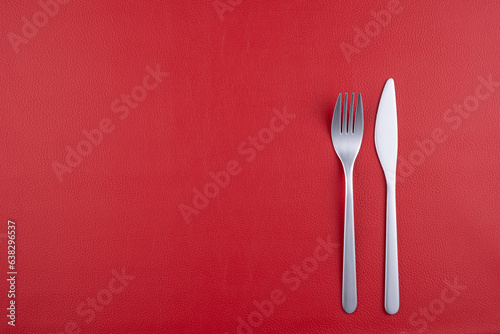 赤いレザーの上に置かれたナイフとフォーク