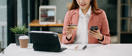 Woman using smart phone for mobile payments online shopping, omni channel, sitting on table, virtual icons graphics interface screen .