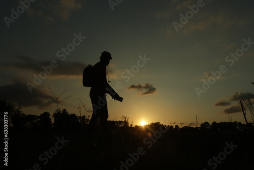 Young man standing at sunset, concept of wanderlust
