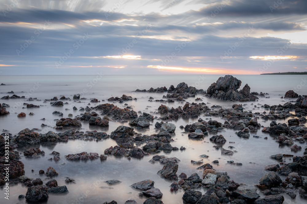 Rocks on a beach at sunset