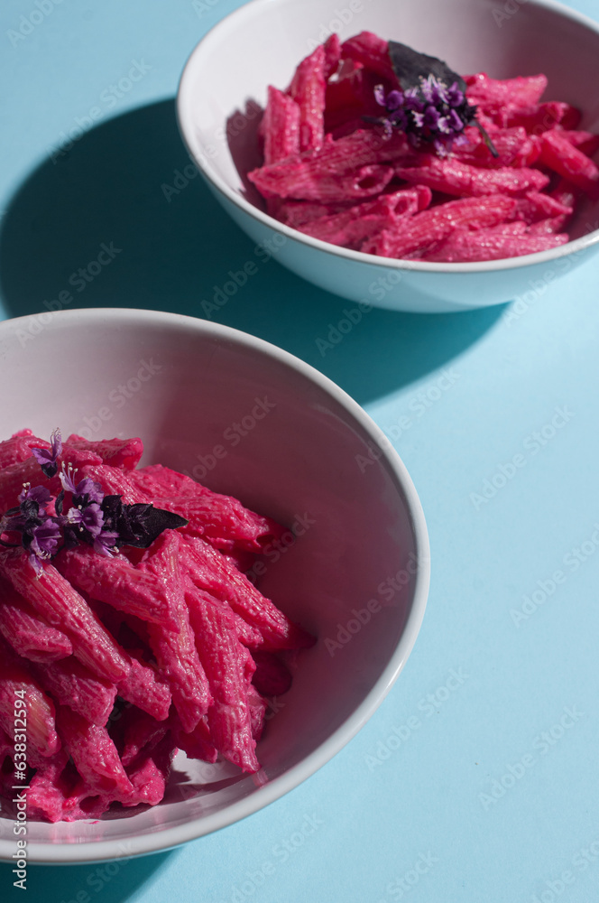 Delicious trendy pink beetroot pasta on minimalist blue background recipe copy space stylish flat lay Delicious trendy pink beetroot pasta on minimalist blue background recipe copy space stylish flat lay
