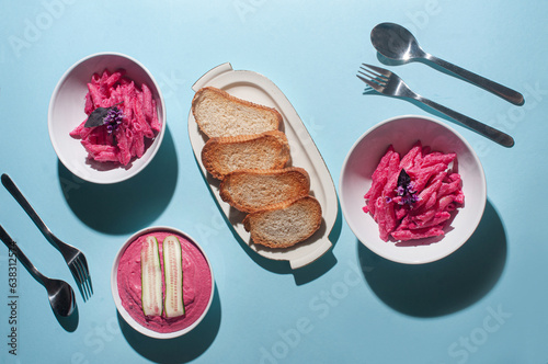 Delicious trendy pink beetroot pasta and hummus on minimalist blue background recipe copy space stylish flat lay photo