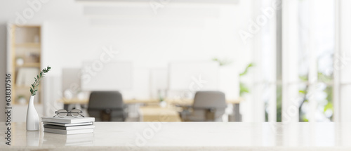 A white tabletop for displaying your product over a blurred bright office room in the background.
