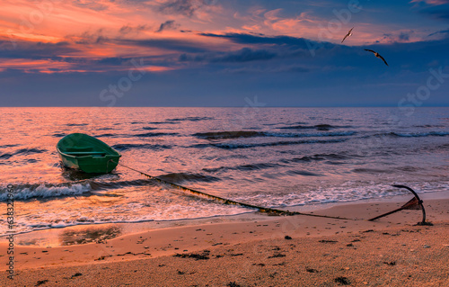 Fishing boat anchored on sandy beach of the Baltic Sea
