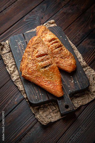 Lush puff with meat, vechina, mushrooms, potatoes on brown boards. For decoration of bakery sales outlets. Bakery products. Fresh bakery.