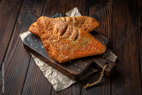 Lush puff with meat, vechina, mushrooms, potatoes on brown boards. For decoration of bakery sales outlets. Bakery products. Fresh bakery.