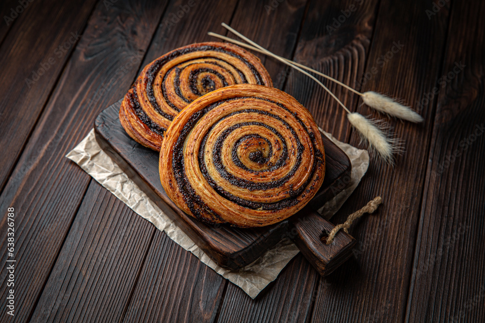 Snail bun with cinnamon and cream on brown boards. Bakery products. Fresh bakery.