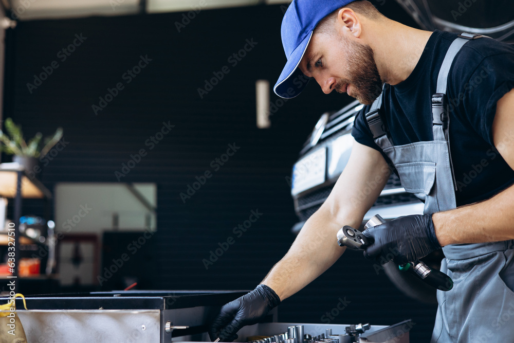 Auto mechanic using wrench and other tools on car service Auto mechanic using wrench and other tools on car service